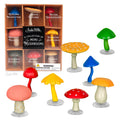 A box containing a collection of soft vinyl mini mushrooms arranged in a fairy circle on display.