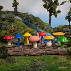 The product, "A Collection of Mini Mushrooms," made from soft vinyl in vibrant colors, is artfully arranged on a wooden surface. These whimsical pieces create a magical fairy circle against the backdrop of a scenic, miniature landscape.