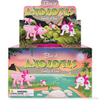 The Box of Axolotls, featuring a delightful axolotl family crafted from soft vinyl, is attractively set against a tropical scene adorned with trees and a breathtaking sunset sky.