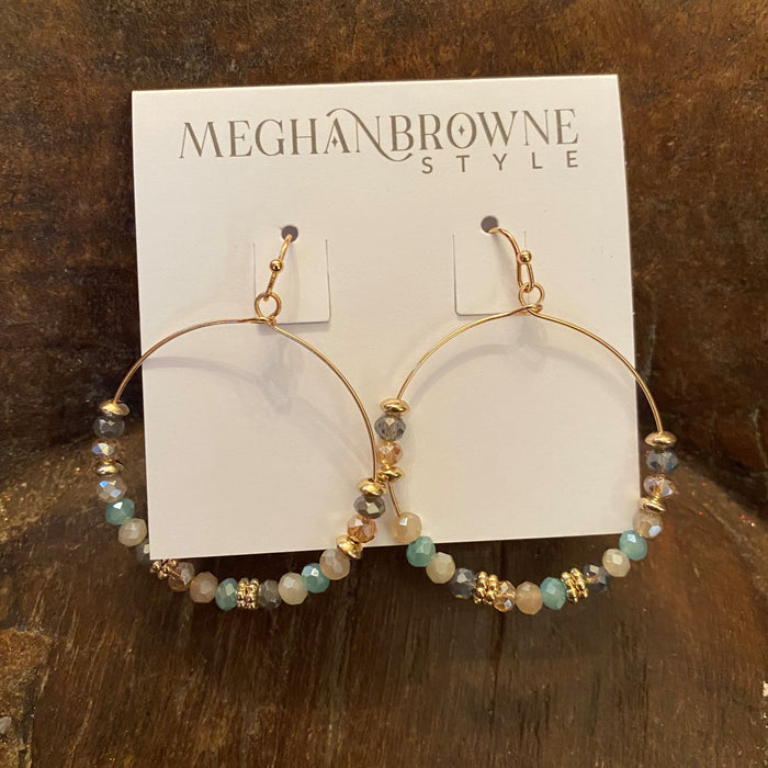 These gold circle earrings with crystals and beads add a unique touch to any wardrobe. Crafted with dainty mint green, gray, gold, and gray crystal beads, these earrings are perfect for adding a touch of subtle sparkle. Wired earrings make them easy to wear.