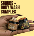 Hand holding cinnamon roll body scrub and gummy bears body wash sample jars on a yellow background