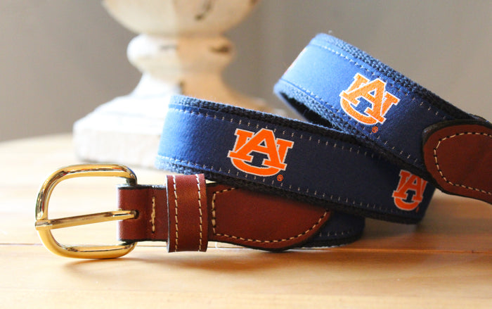 Auburn web belt with leather buckle. Blue ribbon with orange logo.