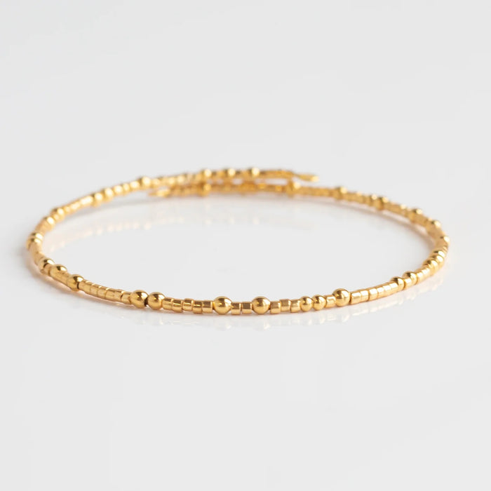 Brighten any outfit with a Confetti Bangle Bracelet! This wrap-style bangle features fun confetti-style beads, with small and larger ones mixing together for a delicate, cheerful look. Show your personality and add a splash of color to any style