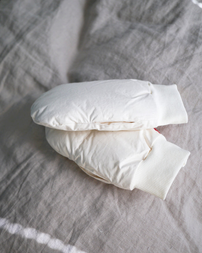 Beige hand warmers by Iwata on a gray textured surface