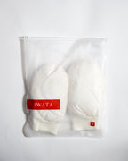 Beige gloves in a bag with IWATA branding on a white background