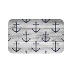 A rectangular gray memory foam mat with a blue anchor pattern against a gray wood plank background and anti-slip backing.