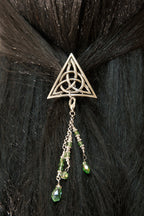Silver Celtic triangle hair hook with green bead charms worn in dark hair
