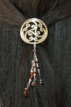 Silver Celtic scrollwork hair hook with bead charms worn in dark hair