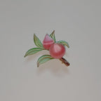 Handcrafted Chanhua peach hair clip featuring pink thread-wrapped peaches and green leaves on a light background.