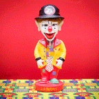 The J.P. Patches Nodder features a clown figure with a colorful outfit and red nose, standing on a patterned surface against a red background, evoking memories of the iconic Seattle children's show.