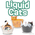 Three cat figurines squished into small glass bowls, resembling quirky bouncing balls, appear beneath the product name Liquid Cats in outlined green text.
