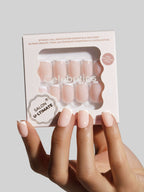 Hand holding a package of press-on nails with Celebritips branding on a light gray background
