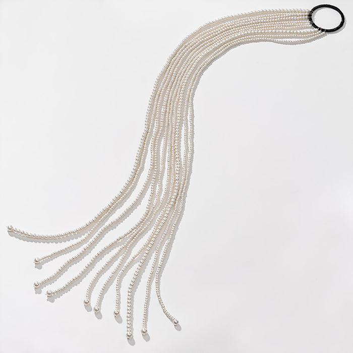 A hanging tassel hair accessory made of pearls, with multiple strands fanning out from a loop at the top.