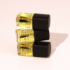 Three bottles of Hanami nail polish with black caps on a light pink background.