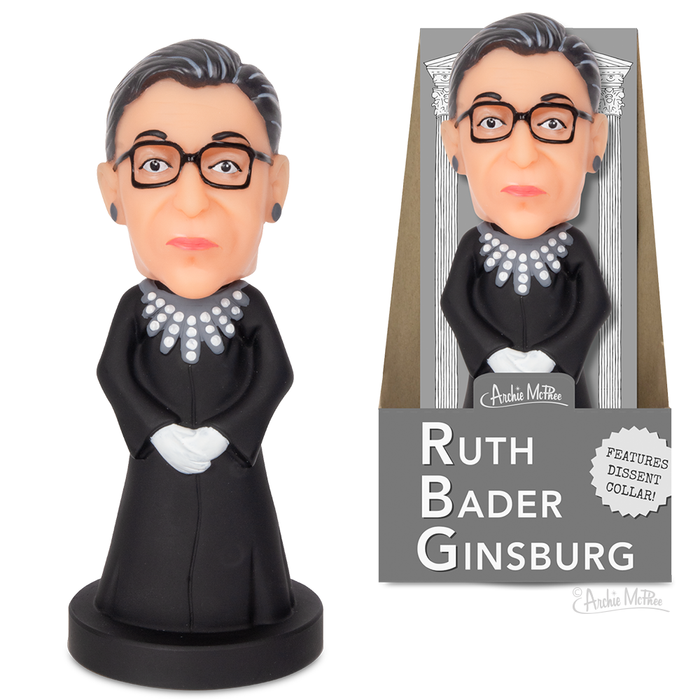 A Ruth Bader Ginsburg Nodder, portraying Supreme Court Justice Ruth Bader Ginsburg wearing a black robe with a dissent collar and glasses, is displayed next to its packaging.
