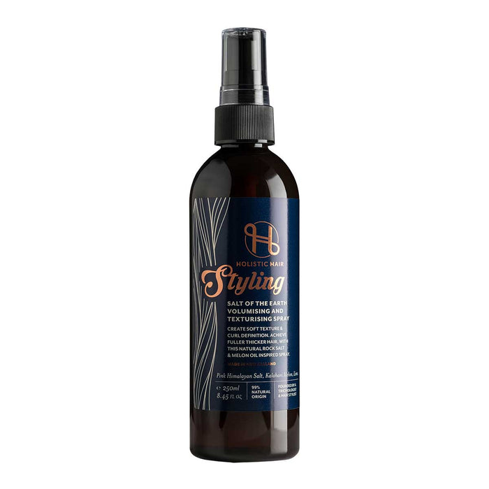 A bottle of Holistic Hair Salt of the Earth Volumising & Texturising Spray with a black label and a spray nozzle on top.