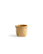 Silhouetted image of small round woven basket by Kohchosai Kosuga against white background.