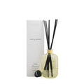 Reed diffuser with black sticks in a clear bottle next to a white box labeled 'Soap & Water'.