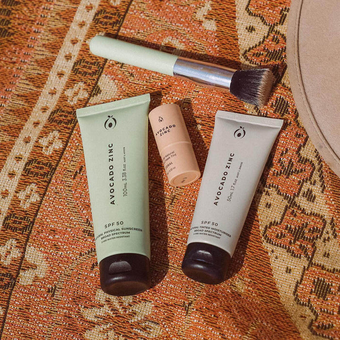 Avocado Zinc skincare products on a patterned fabric background.