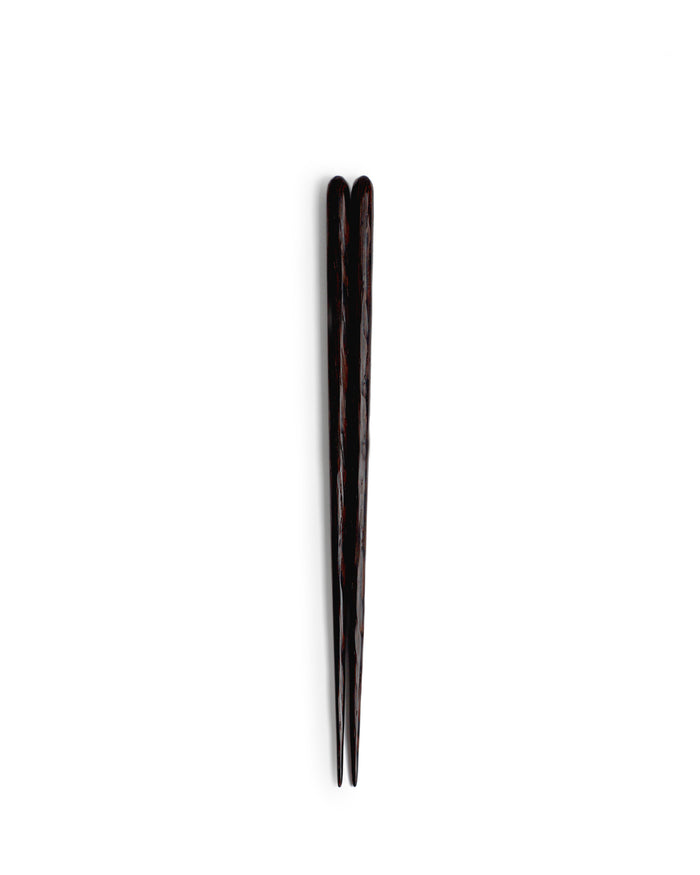 Silhouetted image of set of hand carved tagaya wood chopsticks by Nalata Nalata against white background.