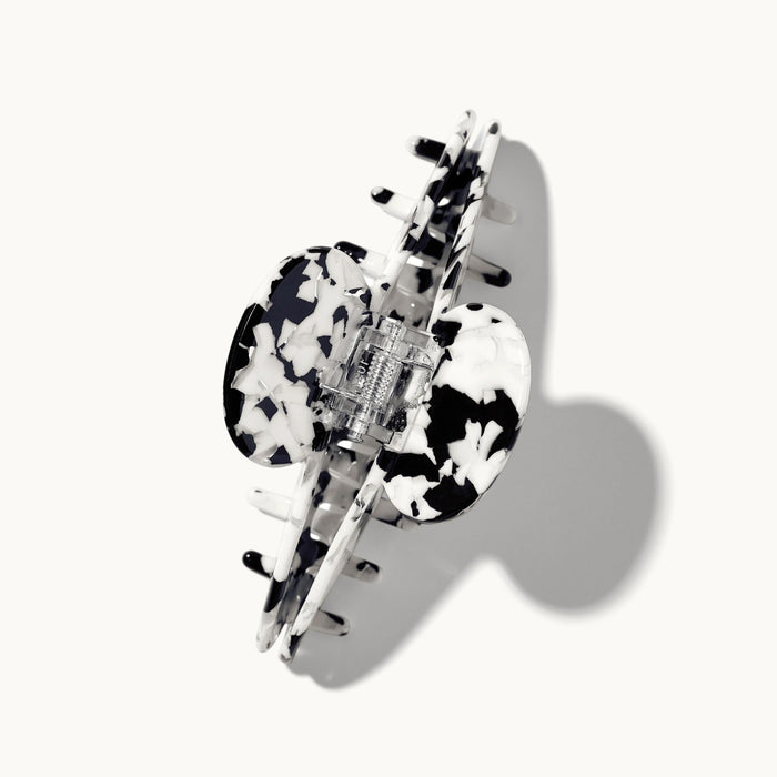 Product shot of the arey tortoiseshell hair clip in black and white pattern on a white background, shown open with the spring hinge mechanism visible.
