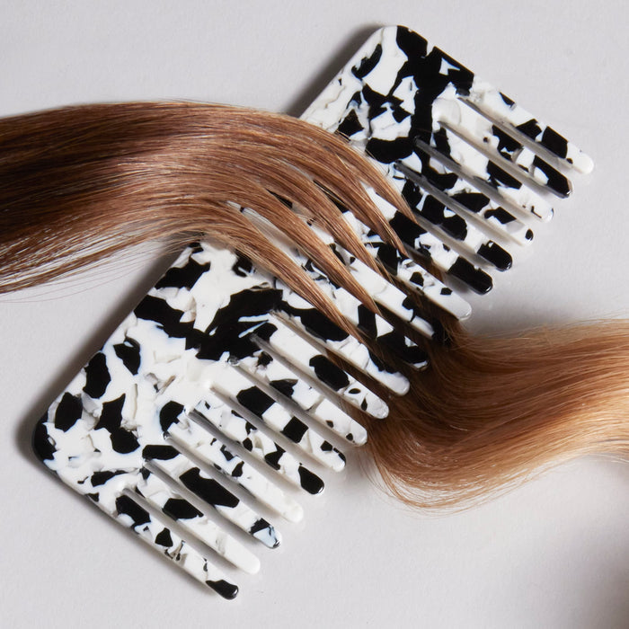 Editorial products of comb with strands of hair in between the teeth