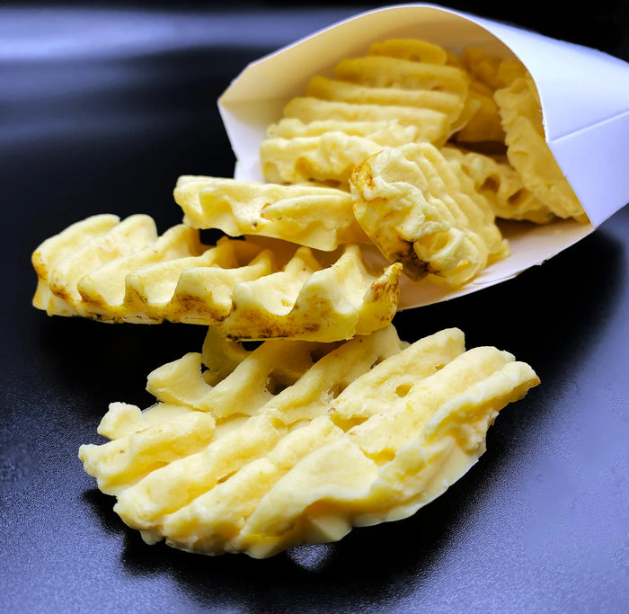 Realistic waffle fries soap in a paper pouch on a black surface, dessert-inspired body care